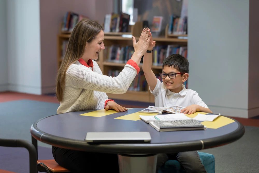 Tutor and student celebrating achievement with a high-five